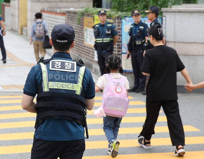 Police officers and a mobile patrol unit conduct after-school patrols near an elementary school in Daegu on Sept. 12. [YONHAP]