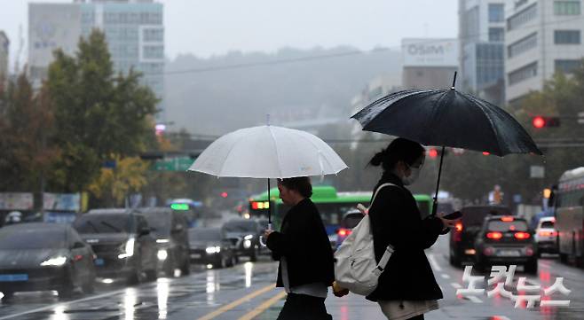 가을비가 내리는 서울 광화문광장 인근에서 시민들이 우산을 쓰고 이동하고 있다. 황진환 기자