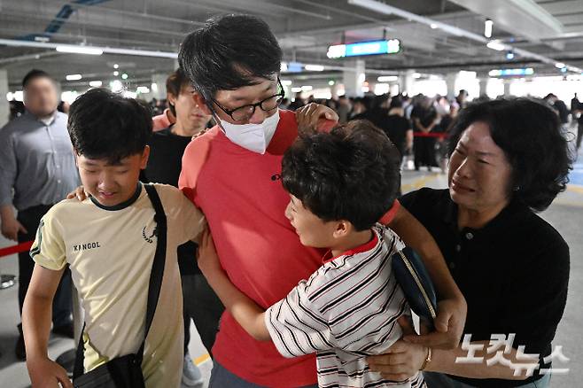 미국 이민당국에 의해 조지아주에 구금됐던 한국인 근로자들이 12일 인천국제공항 제2여객터미널을 통해 귀국한 뒤 주차장에서 가족과 만나고 있다. 인천공항=황진환 기자