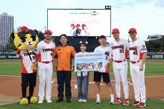 KIA 외국인 선수들이 11일 광주 롯데전을 앞두고 시구자로 초청된 나인엽 소방관, 권다영 간호사, 손기준 경찰관(왼쪽 3번쨰부터 차례로)과 기념사진을 찍고 있다. 외국인 선수는 왼쪽부터 패트릭 위즈덤, 애덤 올러, 제임스 네일. /사진=KIA 타이거즈 제공