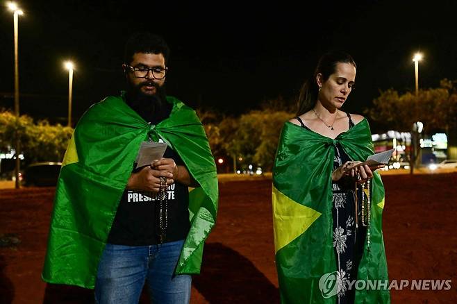 11일(현지시간) '무죄 기원'하는 보우소나루 지지자 [브라질리아 AFP=연합뉴스. 재판매 및 DB 금지]