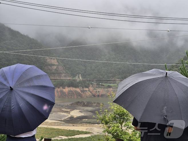 극심한 가뭄을 겪고 있는 강원 강릉지역에 많은 비가 내린 13일 오전 우산을 쓴 시민이 마른 저수지에 내리는 단비를 바라보고 있다. 2025.9.13/뉴스1 ⓒ News1 윤왕근 기자