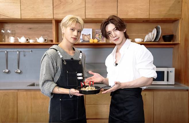 Wooyoung, left, and Yeosang of Ateez present a healthy soy-based dish. [HOGER]