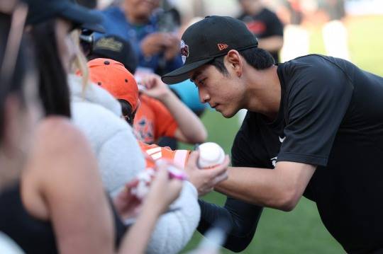 13일 경기 시작 전 팬들에게 사인해주는 이정후. 사진[AFP=연합뉴스]