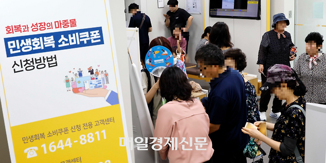 민생회복 소비쿠폰 신청이 시작된 지난 21일 서울 중구 KB국민은행 약수역 종합금융센터에서 시민들이 소비쿠폰 신청 순서를 기다리고 있다. [김호영 기자]