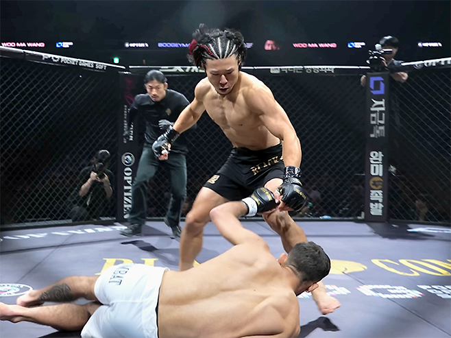 종합격투기 빅리그 ONE Championship 4전 파이터 ‘우마왕’ 우성훈이 2025년 8월 인천광역시 영종국제도시 인스파이어 아레나 블랙컴뱃 15 플라이급 경기에서 라이트훅으로 ‘부기맨’ 한제우 두스산투스를 다운시킨 데 이어 후속 공격 타이밍을 재고 있다. 사진=이데아 파라곤