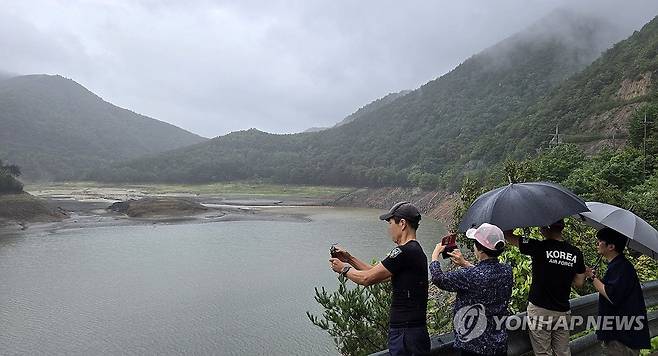 최악 가뭄 강릉에 단비…"더 와야 할 텐데" (강릉=연합뉴스) 유형재 기자 = 최악 가뭄으로 재난사태가 선포된 강원 강릉지역에 13일 비가 내리자 시민들이 상수원인 오봉저수지에 나와 근심스러운 모습으로 저수지 상황을 바라보고 있다. 2025.9.13 yoo21@yna.co.kr