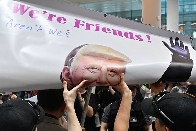 2025년 9월 12일 인천국제공항에서 시위대가 들고 있는 도널드 트럼프 미국 대통령 포스터. /연합뉴스