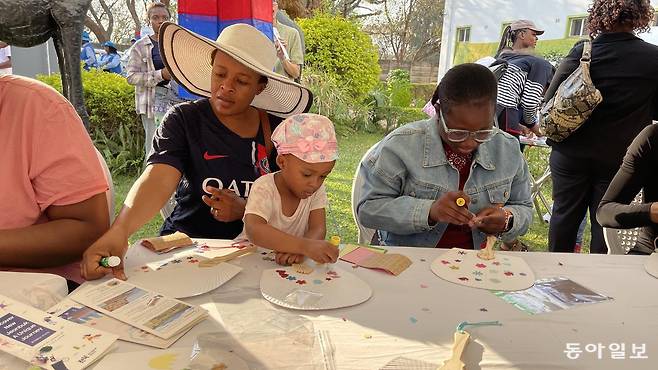 13일(현지 시각) 아프리카 짐바브웨 제2 도시인 블라와요의 뮤직아카데미에서 열린 ‘공공외교 한마당 K-페스티벌’ 참여자들이 한지를 이용해 부채를 장식하는 체험을 하고 있다. 블라와요(짐바브웨)=박영민 기자 minpress@donga.com