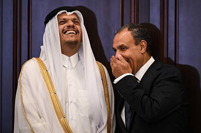 셰이크 무함마드 빈 압둘라흐만 알사니 카타르 총리(왼쪽)와 바드르 압델라티 이집트 외무장관(오른쪽)이 지난 28일(현지시각) 이집트 뉴알라메인시티 내각 본부에서 만나 대화하던 중 웃음을 터뜨리고 있다. EPA 연합뉴스