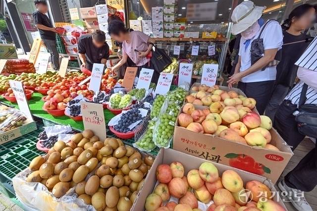 최근 과일 가격이 고공행진을 하고 있는 가운데 유통 과정을 축소해 가격을 낮춘 노상 과일가게들이 인기를 끌고 있다. 사진은 수원특례시내 한 과일가게에서 손님들이 과일을 고르고 있다. 경기일보DB
