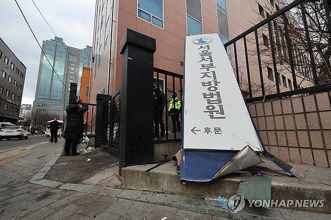 파손된 서부지법 현판 (서울=연합뉴스) 임화영 기자 = 윤석열 대통령이 내란 우두머리 혐의로 구속되자 일부 윤 대통령 지지자들이 서울서부지방법원 내부로 난입해 불법폭력 사태를 일으킨 19일 오전 서부지법 후문 현판이 파손돼있다. 2025.1.19
    hwayoung7@yna.co.k