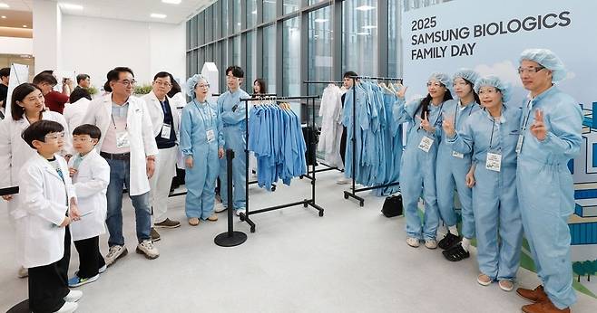 ▲ 삼성바이오로직스가 '2025 임직원 가족 초청행사'를 개최한 가운데 임직원과 가족들이 가운 입기 체험을 진행하고 있다. /사진제공=삼성바이오로직스