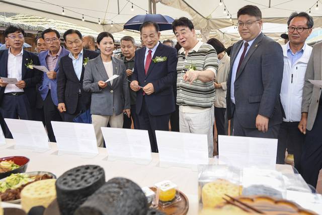 신현국 문경시장이 더본 코리아 백종원 대표와 '가은아자개장터 외식창업 테마파크' 음식을 살펴보고 있다. 문경시 제공.