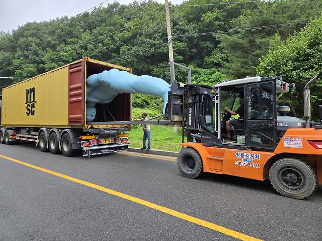6m 크기의 그리팅맨을 스페인 라스팔마스로 운송하기 위해 컨테이너 트럭에 싣고 있다.(사진=유영호 작가)
