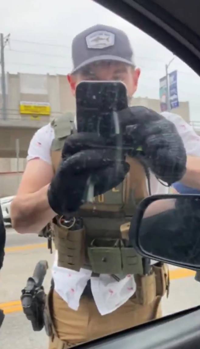 복면을 쓴 미 이민세관단속국(ICE) 요원이 차량에 탑승한 사람을 촬영하는 모습. ICE의 신원 식별 앱 '모바일 모티파이'를 사용하는 것으로 추정되지만, 명확히 밝혀지지는 않았다. /블루스카이