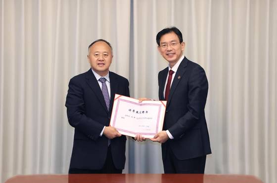 지난 8월 30일 중국 베이징 칭화대에서 류쥔 전 하버드대 교수(왼쪽)가 리루밍 칭화대 총장으로부터 석좌교수 임명장을 받고 있다. 사진 칭화대