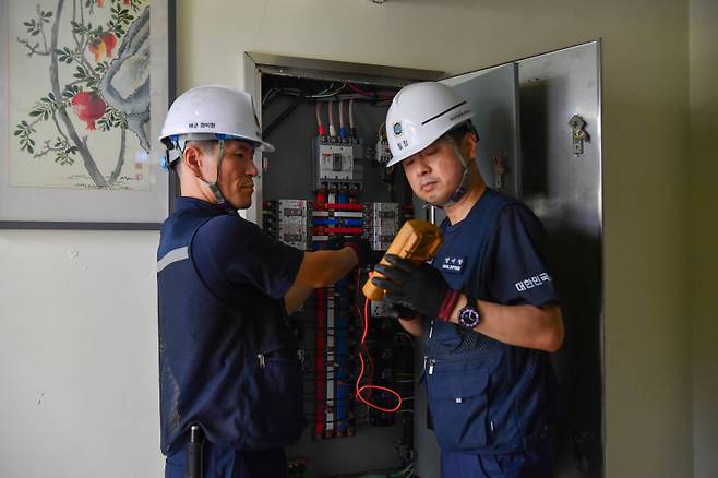 해군군수사령부 정비창 추진제어직장 군무원들이 12일 창원 희망의집에서 전기 안전진단 봉사활동을 하고 있다.