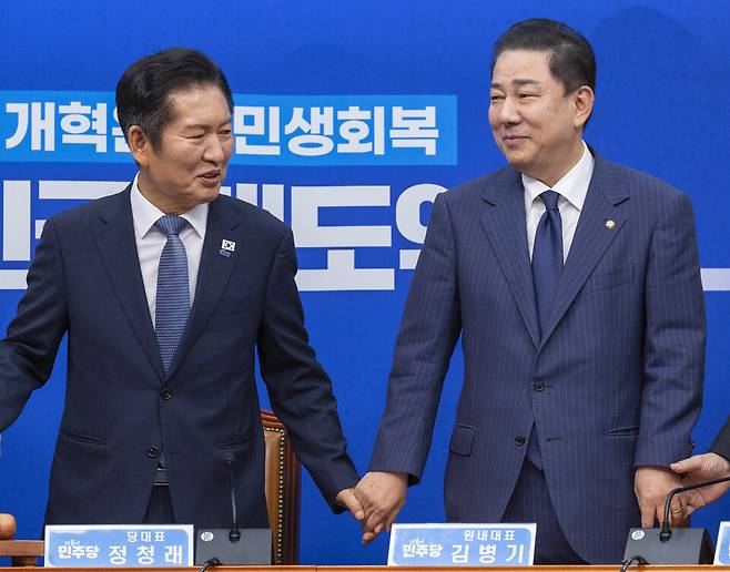 더불어민주당의 정청래&nbsp;대표와 김병기 원내대표를 비롯한 최고위원들이 15일 국회에서 열린 최고위원회의에 입장해 서로 손을 잡고 있다. ⓒ연합뉴스