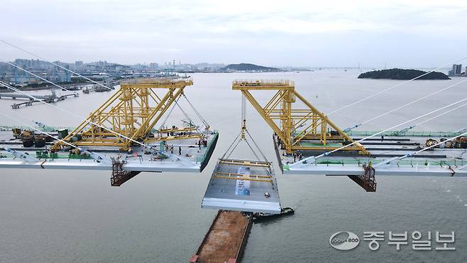 지난 12일 인천시 중구 영종하늘도시와 서구 청라국제도시와를 잇는 제3연륙교 사장교 구간에서 대형 크레인이 마지막 상판을 들어 올려 주탑과 연결하는 작업이 진행되고 있다. 이날 최종 연결은 수개월간 이어진 정밀 시공 끝에 이뤄진 것으로, 제3연륙교가 본격적인 완성 단계에 접어들었음을 알리는 상징적인 순간이 됐다.정선식기자