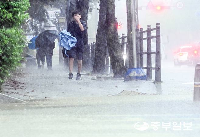 갑작스러운 소나기가 내린 16일 오후 용인시실내체육관 인근 거리에서 한 어린이가 고장난 우산을 들고 발걸음을 재촉하고 있다. 임채운기자