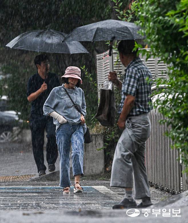 갑작스러운 소나기가 내린 16일 오후 용인시실내체육관 인근 거리에서 시민들이 발걸음을 재촉하고 있다. 임채운기자