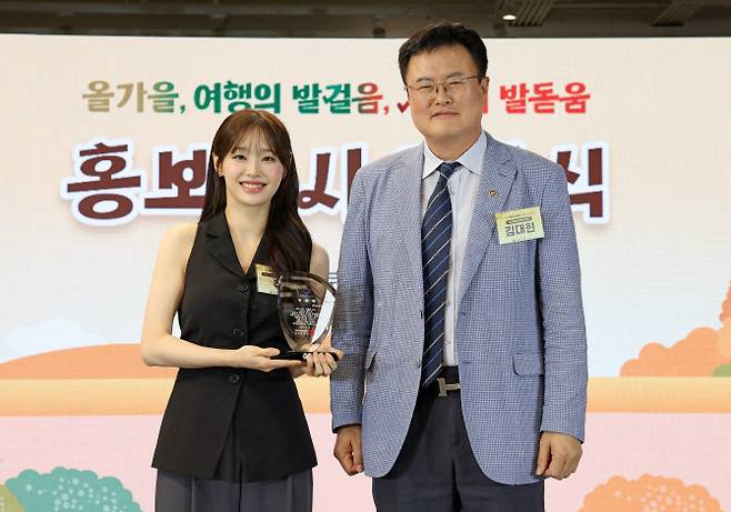 김대현 문화체육관광부 제2차관(사진 오른쪽)이 16일 서울 중구 한국관광공사 서울센터에서 열린 지방살리기 범국민 여행 캠페인 ‘여행가는 가을’ 선포식에 참석해 홍보대사 츄에게 위촉패를 전달한 뒤 기념촬영을 하고 있다. (사진=문체부 제공)