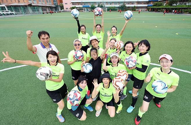 지난 13일 서울 용산구의 한 고등학교 운동장에 모인 FC 더조이플러스 선수단과 변종국(맨 왼쪽 위) 감독. 이주연(맨 왼쪽 아래) 단장 주도로 2023년 결성된 이 팀은 19일 시즈오카현을 찾아 일본 중년 여성 축구단과 친선전을 치른다./장경식 기자