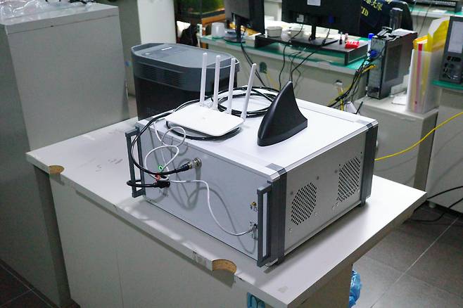 지난 11일 대만 수도 타이베이시 형사수사국 사무실에 놓여 있는 '가짜 기지국' 장비. 컴퓨터 본체와 비슷한 모습의 회색 기지국 장비를 왼쪽 검은색 휴대용 전원장치에 연결해 사용하는 방식이다. 본체 위에는 공유기와 검은색 안테나가 올려져 있다./류재민 특파원