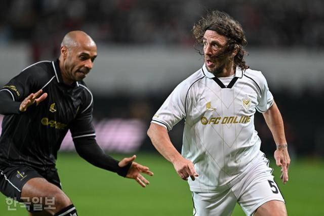 14일 서울월드컵경기장에서 열린 2024 아이콘 매치에서 실드 유나이티드의 카를레스 푸욜(오른쪽)이 FC스피어의 티에리 앙리와 볼 경합을 벌이고 있다. 박시몬 기자