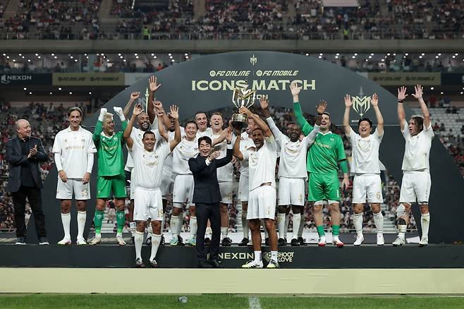 아이콘매치 시상식에서 방패팀 주장 퍼디낸드가 넥슨 박정무 사업부사장과 우승 트로피를 들어 올리고 있다. [사진 넥슨]