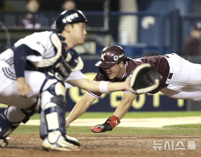 [서울=뉴시스] 정병혁 기자 = 16일 서울 송파구 잠실야구장에서 열린 2025 KBO리그 키움 히어로즈 대 두산 베어스의 경기, 9회초 1사 2, 3루 상황 키움 김태진 희생플라이 때 3루주자 어준서가 홈에 슬라이딩하고 있다.  2025.09.16. jhope@newsis.com