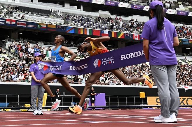 알폰스 펠릭스 심부(왼쪽)와 아마날 페트로스가 15일 일본 도쿄에서 열린 2025 세계육상선수권대회 남자 마라톤에서 거의 동시에 결승선을 통과하고 있다. 둘의 완주 기록은 2시간9분48초로 같았으나, 사진 판독을 진행한 결과 심부가 페트로스보다 0.03초 빨랐다. 도쿄 AFP 연합뉴스