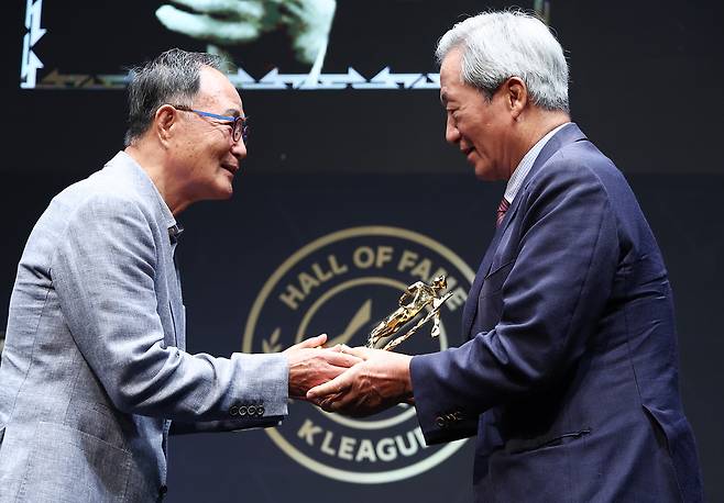 16일 서울 종로구 아산정책연구원에서 열린 2025 K리그 명예의 전당 헌액식에서 정몽준 대한축구협회 명예회장(오른쪽)이 김호곤 축구사랑나눔재단 이사장에게 공헌자 부문 트로피를 받고 있다. 연합뉴스