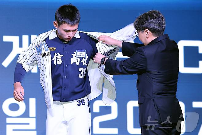 17일 오후 서울 송파구 롯데호텔 월드에서 열린 ‘2026 KBO 신인 드래프트’에서 1라운드 2순위로 NC 다이노스에 선발된 신재인이 유니폼을 입고 있다. 2025.9.17/뉴스1 ⓒ News1 김진환 기자