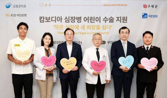 (왼쪽부터)나마디 조엘 진 육상선수, 정현 세종병원 소아청소년과장, 이환주 KB국민은행장, 이명묵 세종병원장, 이세훈 금융감독원 수석부원장, 한세종 구세군 한국군국 서기장관이 17일 경기도 부천에 위치한 세종병원에서 기념촬영을 하고 있다. KB국민은행 제공