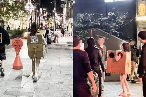서울 압구정, 홍대 등 번화가에서 알몸에 박스만 걸친 채 길거리를 활보하며 자신의 신체를 만지라고 권한 여성. 사진은 서울 압구정동에서 포착된 이 여성의 모습. 사진 온라인 커뮤니티 캡처