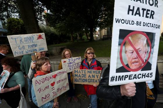 16일(현지시간) 영국 윈저성 앞에서 진행된 '반트럼프 집회'에서 집회 참석자들이 트럼프 대통령을 비난하는 내용의 플래카드를 들고 있다. 로이터=연합뉴스