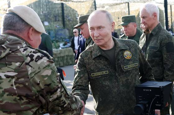 16일(현지시간) 블라디미르 푸틴 러시아 대통령이 군복을 입은 채 러시아 니즈니노브고로드에서 열린 대규모 연합 군사훈련 ‘자파드 2025’를 찾아 관계자들과 인사를 하고 있다. [AFP=연합뉴스]