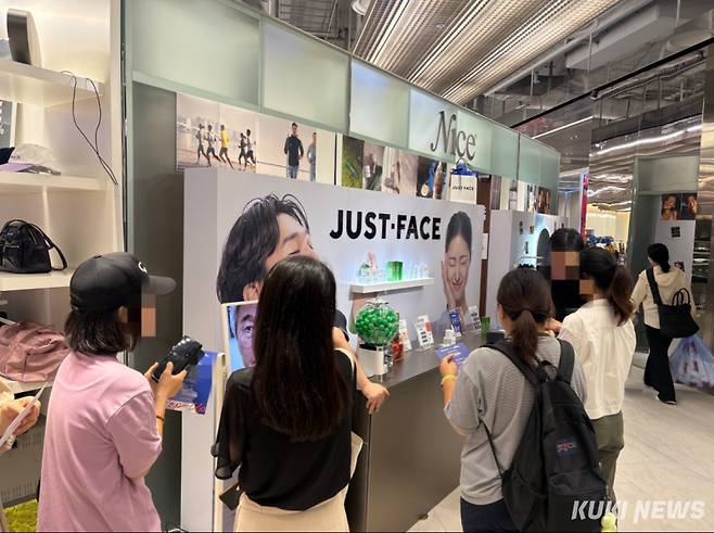 더현대서울 지하 2층 화장품 팝업 부스를 방문한 고객들이 이벤트에 참여하고 있다. 이다빈 기자