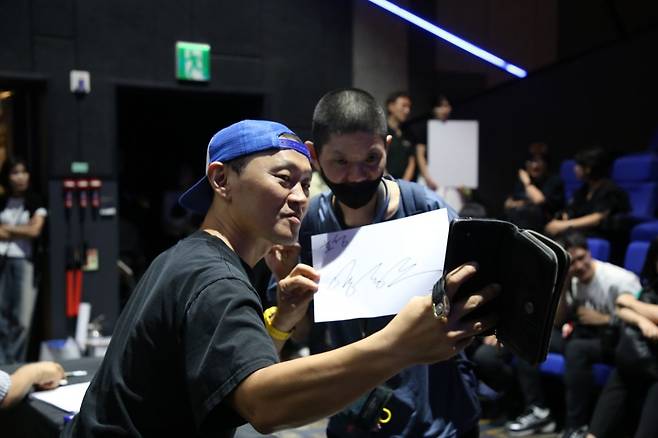 밀알복지재단 굿윌스토어의 장애 직원이 지난 15일 서울 송파구 롯데시네마에서 배우 양동근씨의 사인을 받은 뒤 기념 촬영을 하고 있다. 밀알복지재단 제공