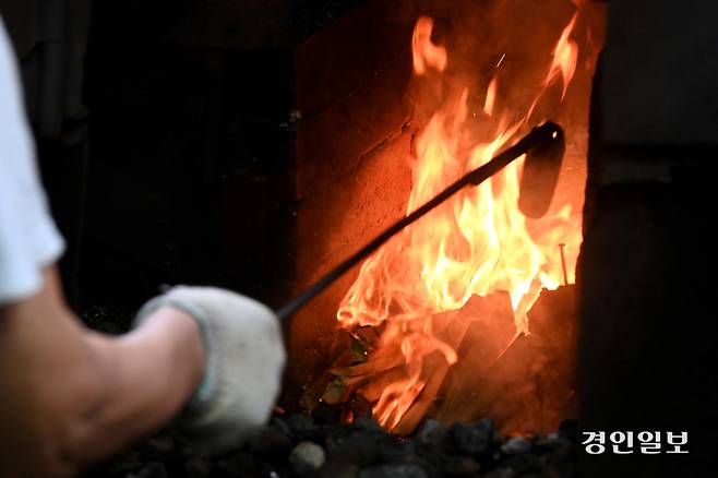 쇠를 달구기 위해 화덕에 불을 피우고 있다.