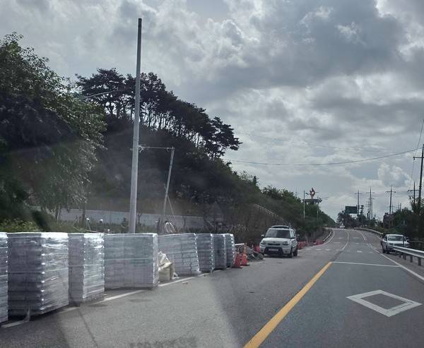 공사장 주변 인도와 도로에 쌓아놓은 건설 자재 [사진 = 한의동 기자]