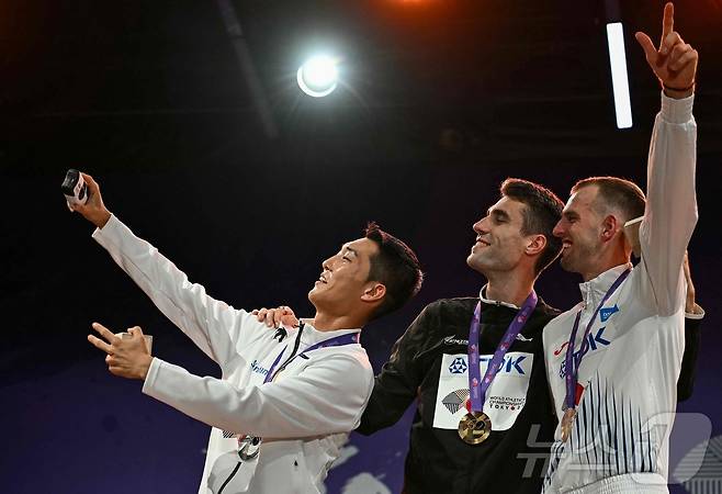 지난 17일 열린 세계선수권 남자 높이뛰기 시상식에서 우상혁과 해미시 커, 얀 슈테펠라(왼쪽부터)가 사진을 찍고 있다. ⓒ AFP=뉴스1