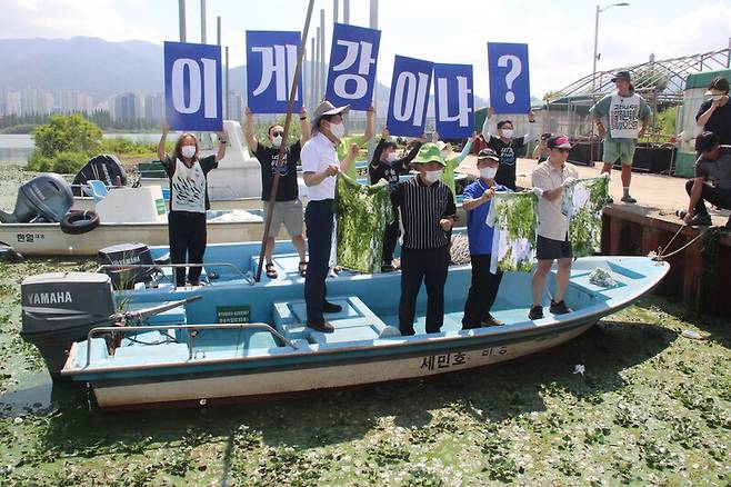 지난 3일 경남 김해 대동선착장에서 환경운동가와 국회의원 등이 배에 올라 “이게 강이냐”라고 쓴 피켓을 들고 시위하고 있다. 김규원 선임기자