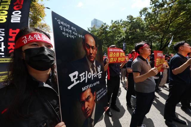 금감원 직원들이 18일 서울 영등포구 여의도에서 열린 금융소비자보호원 분리 및 공공기관 지정 반대 집회에서 손팻말을 들고 있다. 연합뉴스