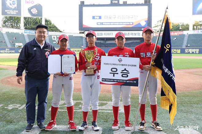 ‘2025 두산베어스기 어린이야구대회’ 리틀부 우승팀 마포구 리틀야구단이 18일 잠실구장에서 진행된 시상식에 참석했다. 김태룡 두산 단장(왼쪽)과 선수들이 기념촬영을 하고 있다. 사진제공｜두산 베어스