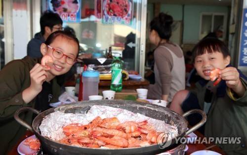 "대하 맛 최고예요" (태안=연합뉴스) 충남 태안군의 대표 수산물 대하를 맛볼 수 있는 대하축제가 30일 안면도 백사장항에서 열리고 있는 가운데 관광객들이 대하 소금구이를 먹고 있다. 내달 14일까지 계속될 이번 축제는 맨손대하잡기, 어린이낚시왕 선발대회 등이 이어진다. 2018.9.30 [태안군 제공]