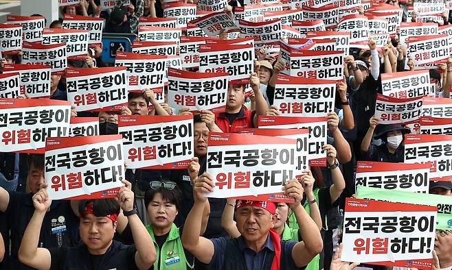 인천국제공항 노동자가 가입한 민주노총 공공운수노조 인천공항지역지부와 나머지 14개 공항 노동자가 가입한 전국공항노동조합으로 구성된 전국공항노동자연대가 19일 인천 영종도 인천국제공항 제2여객터미널에서 연 총파업 대회에서 참가자들이 손팻말을 들고 구호를 외치고 있다. 전국공항노동자연대는 이날 경고 파업을 진행한 후 추석 연휴 전 무기한 총파업을 진행할 것이라고 예고했다. 연합뉴스