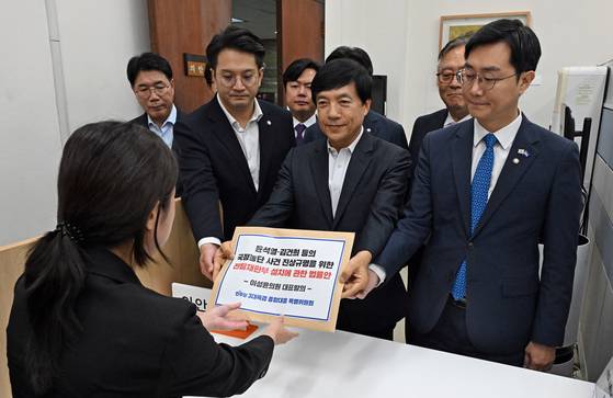 더불어민주당 3대 특검 종합대응 특별위원들이 18일 ‘국정농단 사건 진상규명을 위한 전담재판부 설치법안’을 국회 의안과에 제출하고 있다. [뉴시스]